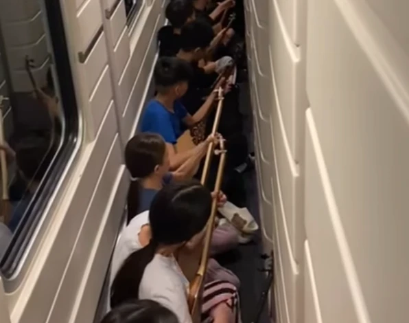 Poıyzda kúı tartqan jas dombyrashylar jolaýshylardy tánti etti